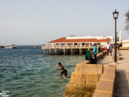 Kids jumping of stone wall of Forodhani Gardens, Stone Town, Zanzibar